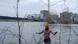 Reporter wading in ice-cold water with a power plant in the background Reporter wading in ice-cold water with a power plant in the background