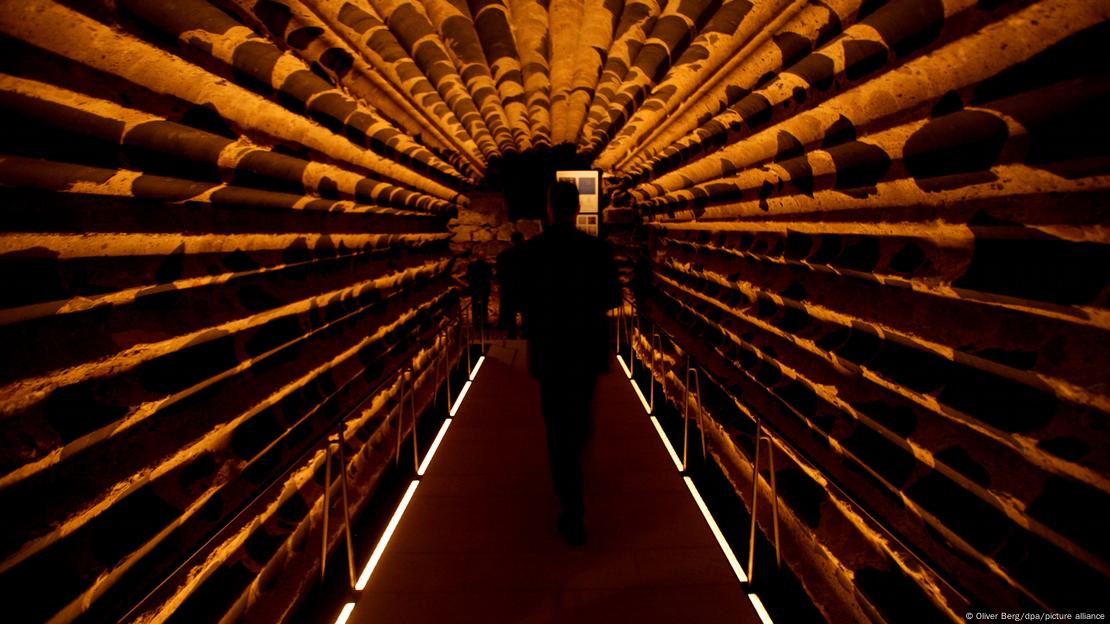 Un hombre camina por un túnel de acceso a la catedral de Colonia.