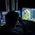 Ein Mann sitzt vor zwei Bildschirmen und spielt ein PC-Spiel