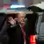 Donald Trump winkt in die Kamera vor einer Autokolonne