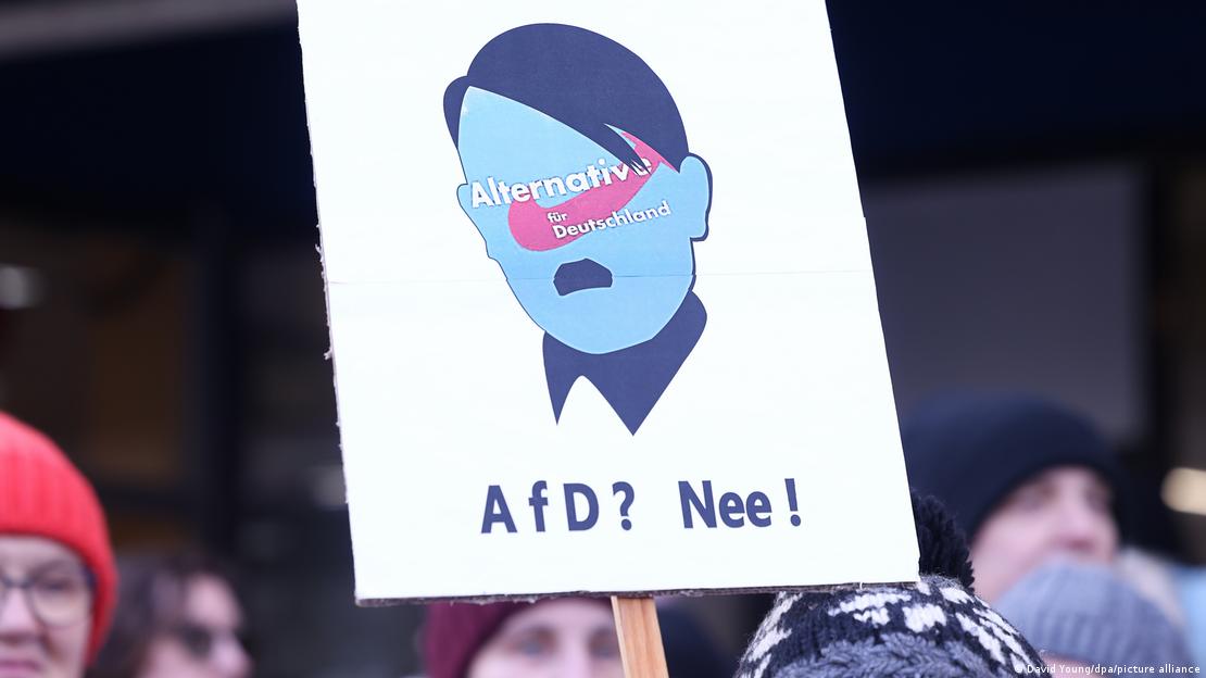 Πλακάτ με το λογότυπο της AfD πάνω σε ένα πρόσωπο με το μουστάκι και το κούρεμα του Χίτλερ