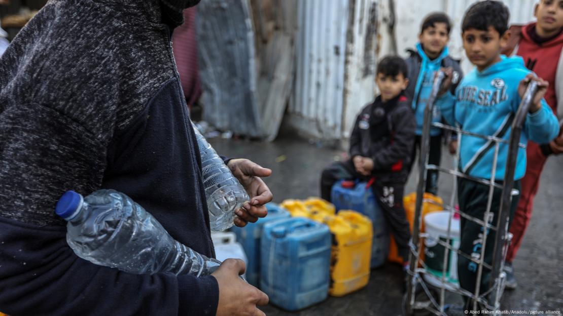 Un hombre lleva botellas de agua en la Franja de Gaza.