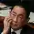 Fumio Kishida scratches his face at a parliamentary session in Japan