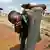 A boy drinks water from a tap in eastern Sierra Leone