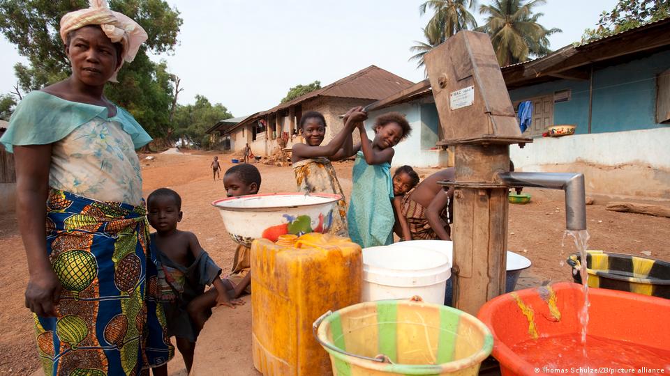 Children pump clean water into bowls and canisters in Makeni, a town in the northeast of Sierra Leone