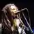 Jamaika Reggae-Sänger Bob Marley singt in ein Mikrofon.