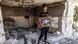 A young man carries pictures of his family that he extracted from the rubble of his destroyed house A young man carries pictures of his family that he extracted from the rubble of his destroyed house