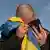 Muškarac drži u ruci mobilni telefon i ukrajinsku zastavu