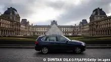 A car drives past the Louvre Museum in Paris city centre on February 2, 2024 as Paris' city hall is organising a vote on February 4 on the creation of a special parking fee for heaviest and most polluting cars and SUVs. (Photo by Dimitar DILKOFF / AFP) (Photo by DIMITAR DILKOFF/AFP via Getty Images)