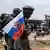 در وسط یک خیابان واقع در یک کشور آفریقایی، پرچم روسیه در دست تندیس سرباز آفریقایی نشانده شده است