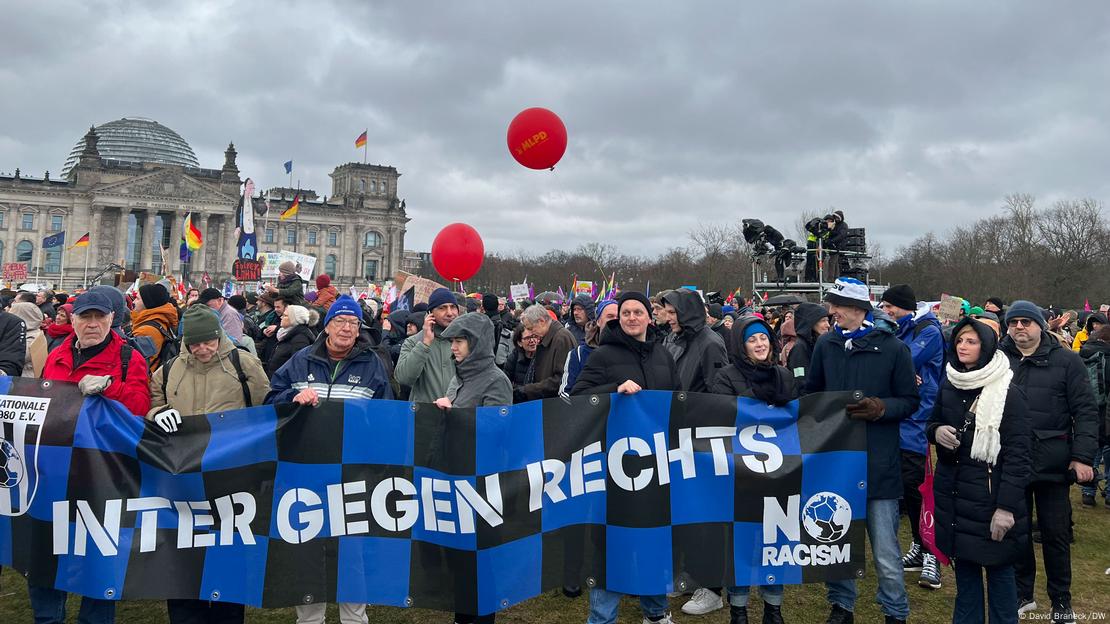 Demonstranten gegen Rechtsextremismus mit einem blau-schwarz karierten Transparent mit der Aufschrift "Inter gegen rechts" vor dem Berliner Reichstag