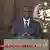 President Macky Sall speaking from a podium with the flag of Senegal behind him