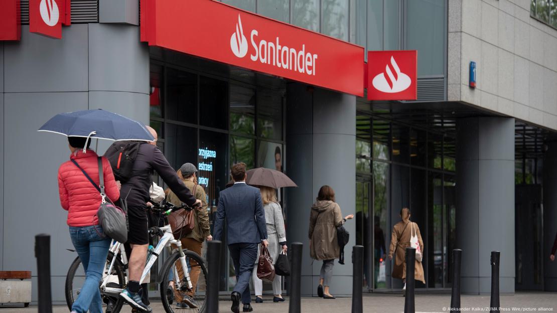 Pessoas caminham em frente a uma agência do Santander