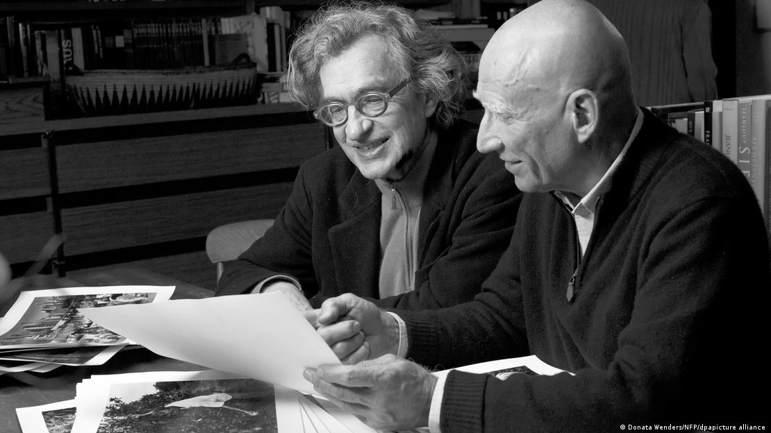 Salgado muestra algunas de sus fotografías al cineasta alemán.