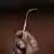 Afrika/Gambia: eine Hand hält ein selbstgemachtes Messer (von einem Nagel) mit flacher Spitze, ein Werkzeug für die Genitalverstümmelung