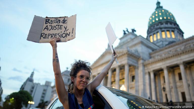 Mujer levanta cartel contre el ajuste frente al Congreso.