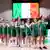The Ireland women's basketball team singing the national anthem, standing in a line with their hands on each other's shoulders