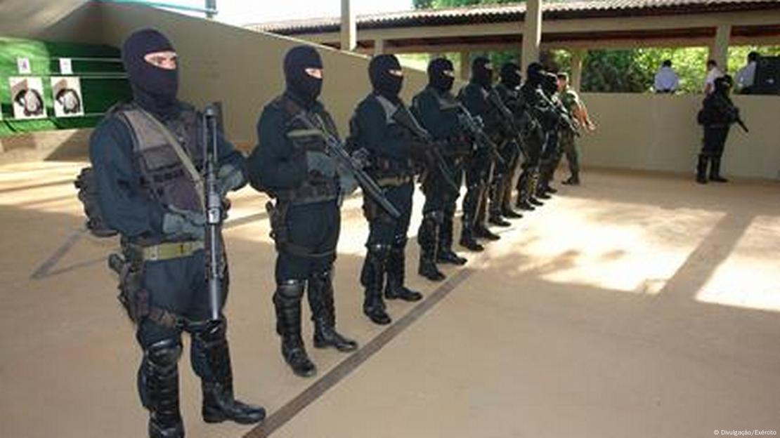 Homens com uniforme preto, armas e beleclava preta, enfileirados