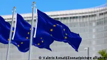 12/10/2023**ARCHIVBILD**European union flag waving with European Commission headquarters blurred in the background. Political and economic union. 3d illustration render. Rippling fabric. Selective focus