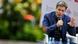 El ministro gesticula con una mano mientras sostiene el micrófono con la otra. El ministro gesticula con una mano mientras sostiene el micrófono con la otra.