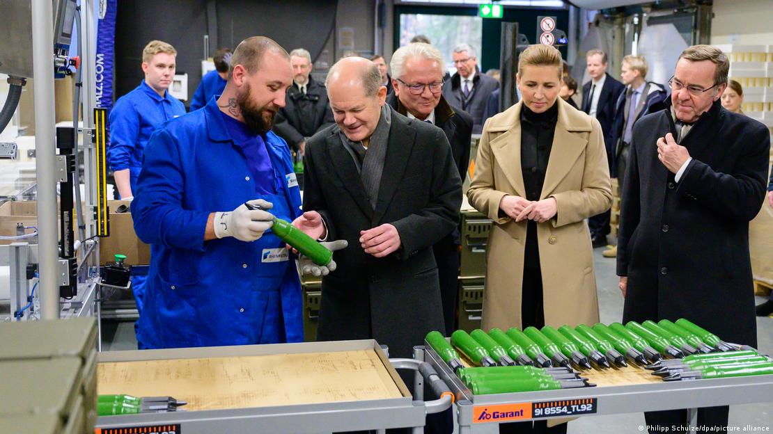 Njemačkom kancelaru Scholzu i predstavnicima vlade radnik Rheinmetalla pokazuje topničko streljivo koje proizvodi