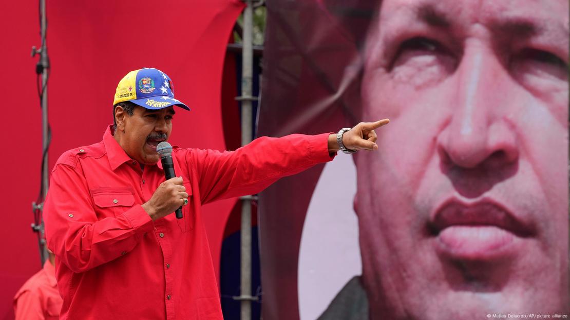 El presidente de Venezuela, Nicolás Maduro, pronuncia un discurso con la imagen de Hugo Chávez de fondo.
