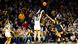 Clark shoots the ball over the outstretched hand of a rival in front of a large crowd of fans Clark shoots the ball over the outstretched hand of a rival in front of a large crowd of fans