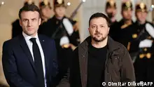 EDITORS NOTE: Graphic content / France's President Emmanuel Macron (L) shakes hands with Ukraine's President Volodymyr Zelensky (R) upon his arrival at the presidential Elysee palace in Paris on February 16, 2024, to sign a bilateral security agreement. After touching down at Orly airport south of the capital, Zelensky meets with French President to sign the deal, having concluded a similar agreement with Germany earlier in the day. (Photo by Dimitar DILKOFF / AFP)
