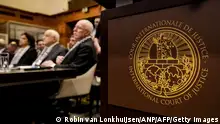 The Logo of the International Court of Justice (ICJ) is seen next to Minister of Foreign Affairs of the Palestinian Authority Riyad al-Maliki (R) and members of his delegation as they listen at the start of a hearing at the ICJ on the legal consequences of the Israeli occupation of Palestinian territories, in The Hague on February 19, 2024. (Photo by Robin van Lonkhuijsen / ANP / AFP) / Netherlands OUT (Photo by ROBIN VAN LONKHUIJSEN/ANP/AFP via Getty Images)