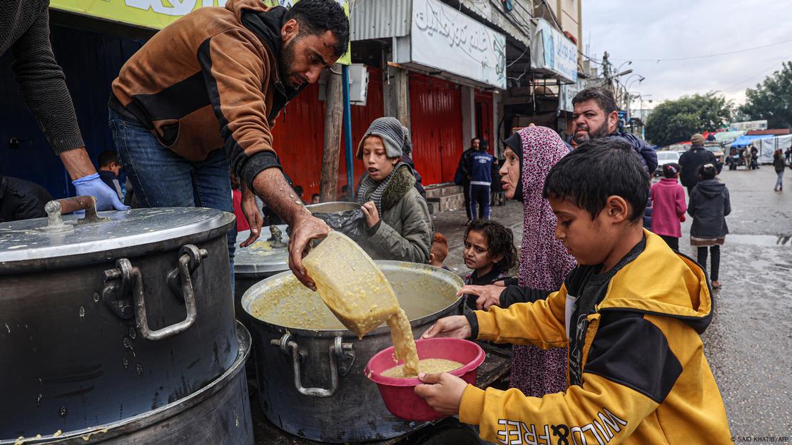 Un voluntario distribuye raciones de sopa de lentejas a palestinos desplazados en Rafah, en el sur de la Franja de Gaza (imagen de archivo)
