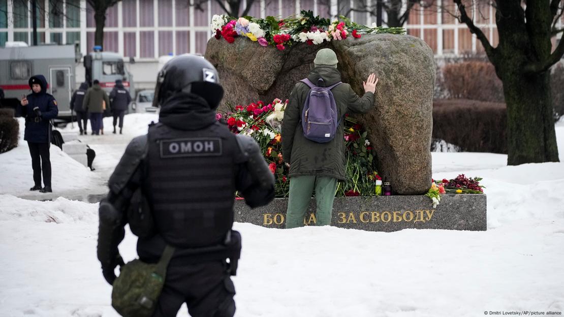 Ein Mann legt an einem Denkmal in St. Petersburg Blumen für Nawalny nieder 