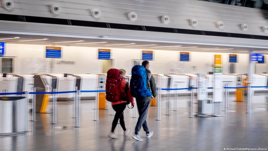 Passengers walk through a terminal at Frankfurt Airport amid the Verdi union action  