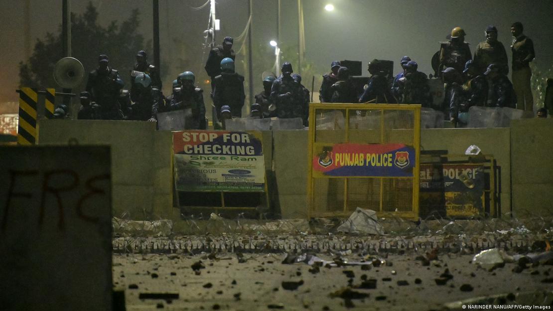Police and Rapid Action Force (RAF) personnel in riot gear block a highway to stop farmers from marching towards New Delhi during a protest demanding minimum crop prices