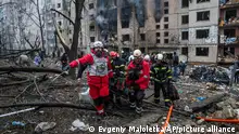 Red Cross volunteers and rescue workers carry a disabled man on a stretcher from a building which was damaged by a Russian rocket attack, in Kyiv, Ukraine, Tuesday, Jan. 2, 2024. (AP Photo/Evgeniy Maloletka)