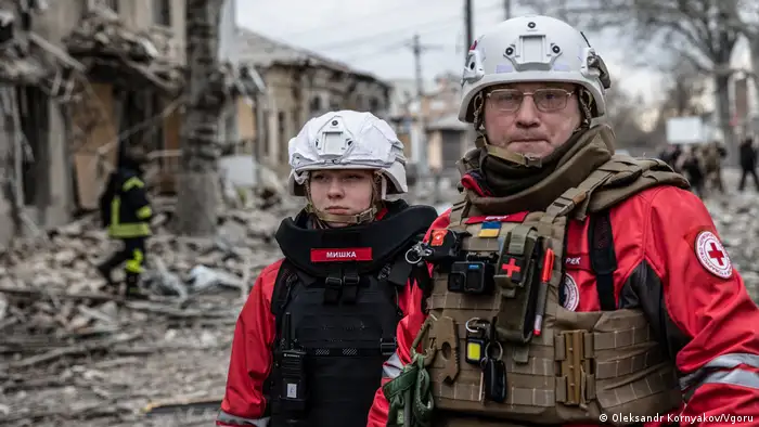 First responders stand in rubble on a street in Kherson
