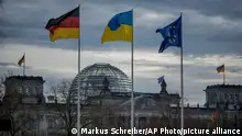 A German, Ukrainian and European flag wave in front of the Reichstag building in Berlin, Germany, Friday, Feb.16, 2024. German Chancellor Olaf Scholz will meet Ukrainian President Volodymyr Zelenskyy on Friday. (AP Photo/Markus Schreiber)