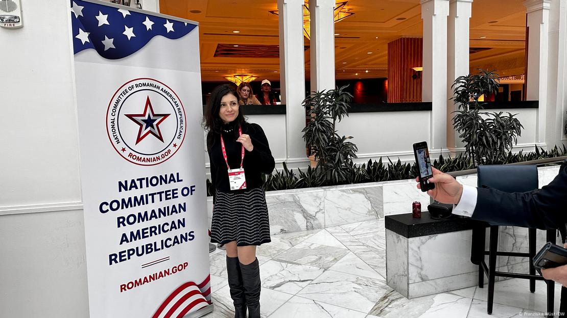 USA | Conservative Political Action Conference 2024 - Monica Cotenescu, Vize-Präsidentin der Republikanischen Partei Rumäniens, präsentiert sich vor einem Banner des Komitees der republikanischen rumänischstämmigen Amerikaner