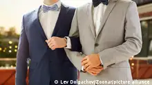 homosexuality, same-sex marriage and lgbt concept - close up of happy male gay couple holding hands on wedding over roof top party background || Modellfreigabe vorhanden