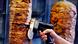 A man slices cuts of meat from a rotisserie döner spit inside a döner restaurant cafe in Frankfurt on November 30, 2017 A man slices cuts of meat from a rotisserie döner spit inside a döner restaurant cafe in Frankfurt on November 30, 2017