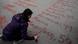 Φοιτήτρια γράφει τα ονόματα των θυμάτων με κόκκινη μπογιά στην πλατεία Συντάγματος