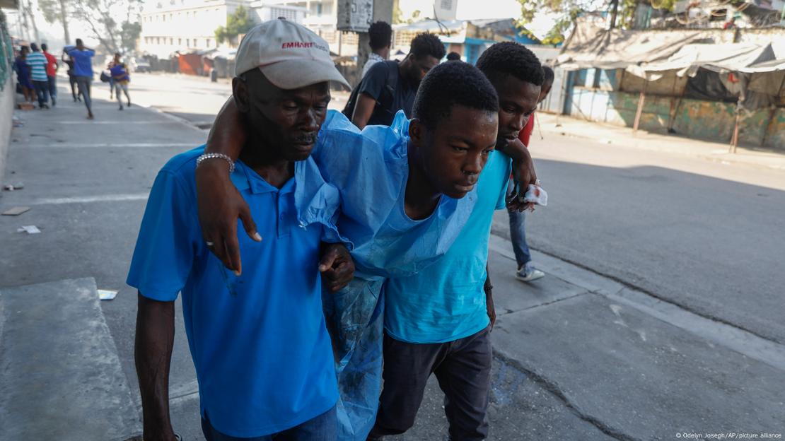 Un hombre herido durante los tiroteos es auxliado para ser evacuado hacia el Hospital General en Puerto Príncipe.