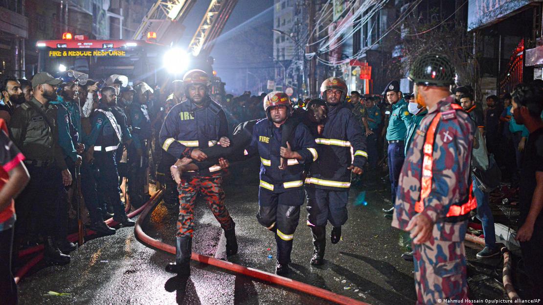 Los bomberos trasladan a una de las víctimas del incendio. 