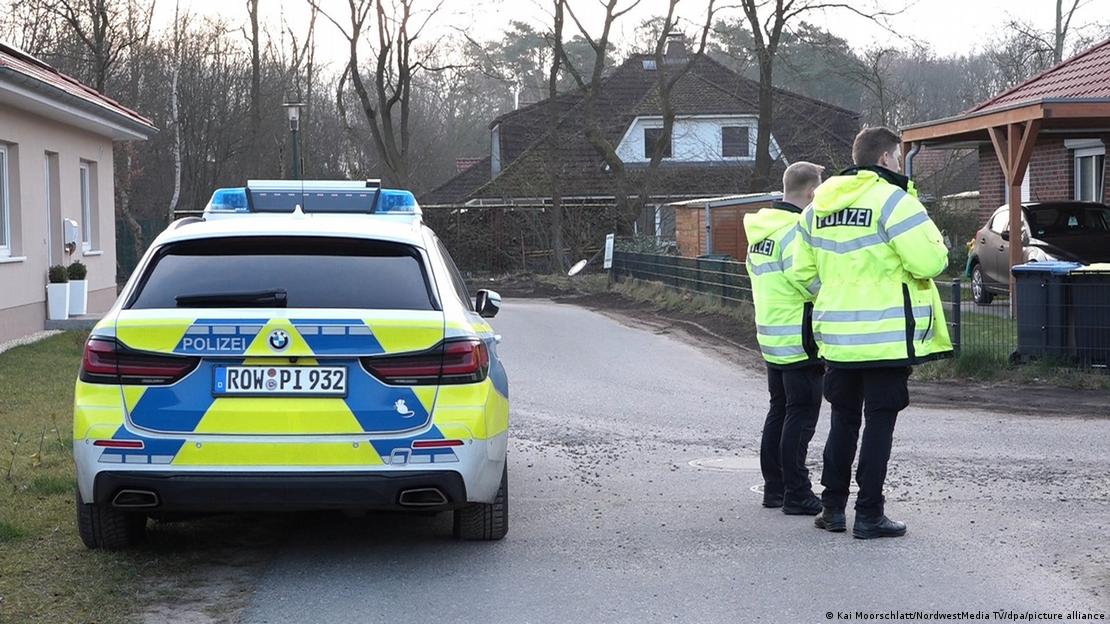 A police car and two officers obstruct a road in Bothel, near the site of a shooting the previous night. March 1, 2024.