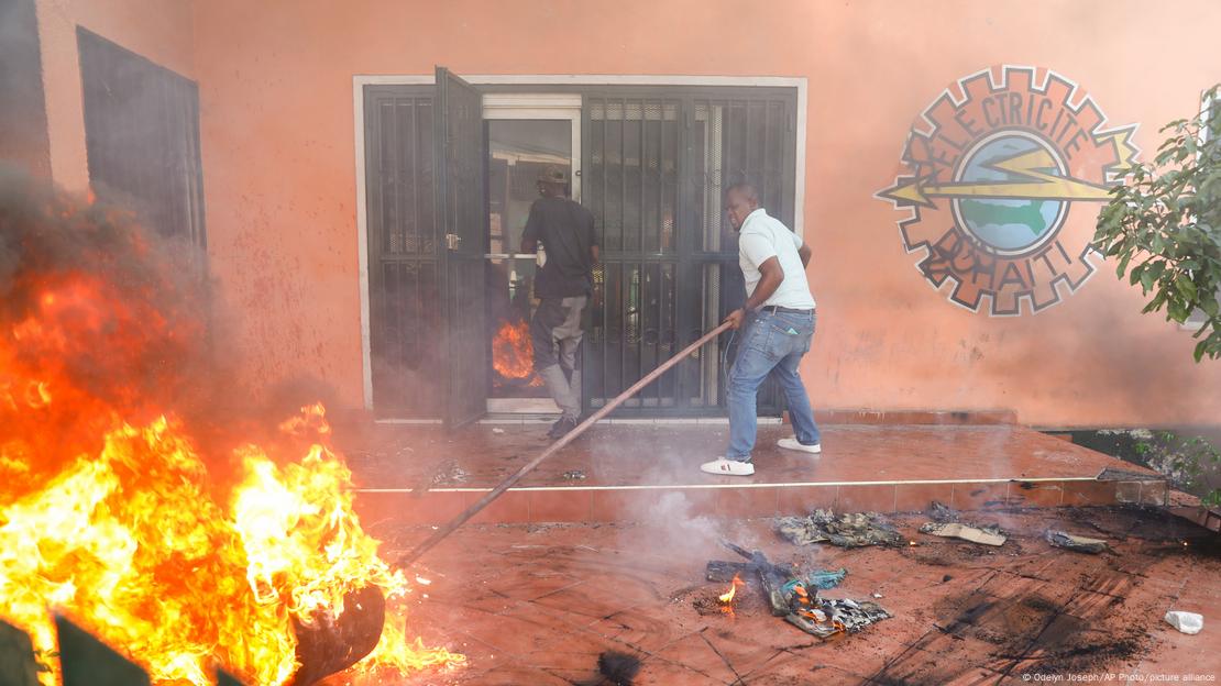 Trabajadores de una empresa eléctrica de Puerto Príncipe sofocan un incendio durante las protestas contra el gobierno de Ariel Henry el viernes (01.03.2024).