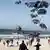 加沙民众奔向落在海滩的美军援助物资