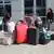 Mehrere Frauen und Mädchen sitzen wartend zwischen Koffern und Reisetaschen