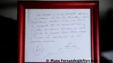 In this photo taken, Thursday, Jan. 5, 2012, a framed copy of the napkin linking a 13-year-old Lionel Messi to FC Barcelona is seen in Barcelona, Spain. The club's technical secretary and past coach Carles Rexach scribbled out an informal contract on a napkin, the closest piece of paper he could find at Barcelona's Pompei Tennis Club. The small napkin reads: In Barcelona, on the 14th of December of 2000 and in the presence of Josep Minguella and Horacio (Gaggioli), Carles Rexach, F.C.B technical secretary, it commits under his responsibility and despite some views against it to sign the player Lionel Messi, as long we stick to amounts agreed upon.(AP Photo/Manu Fernandez)