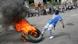A man kicks burning tires during a protest in Port-au-Prince, Haiti, March 7, 2024. A man kicks burning tires during a protest in Port-au-Prince, Haiti, March 7, 2024.