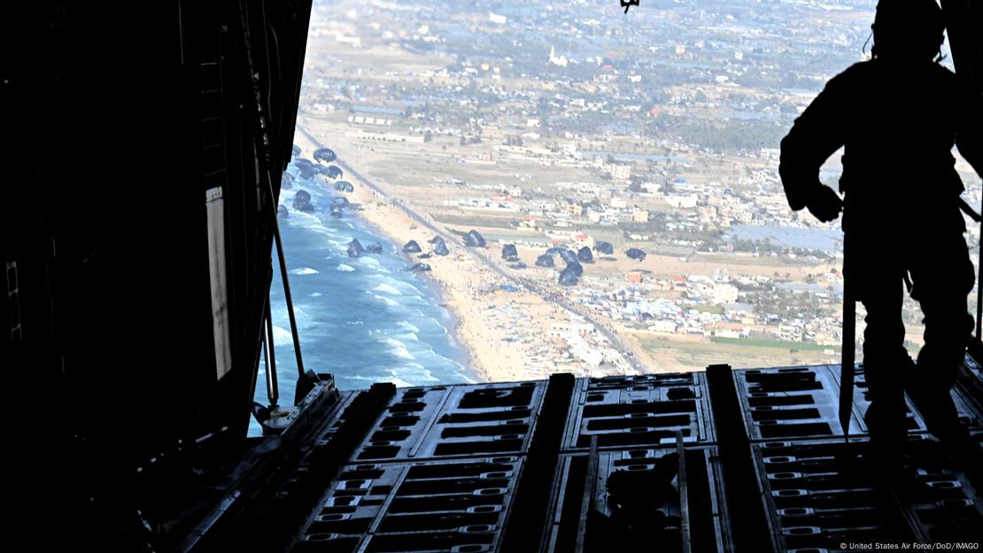 Visão da parte traseira aberta de avião militar de carga logo após lançamento de pacotes de ajuda