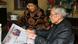 An elderly Chinese couple reading the newspaper together